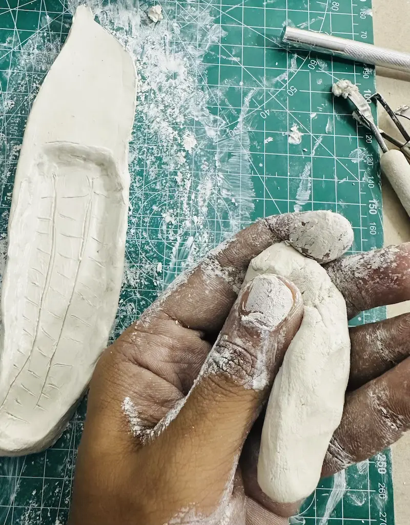 kneading clay to make the banana peels