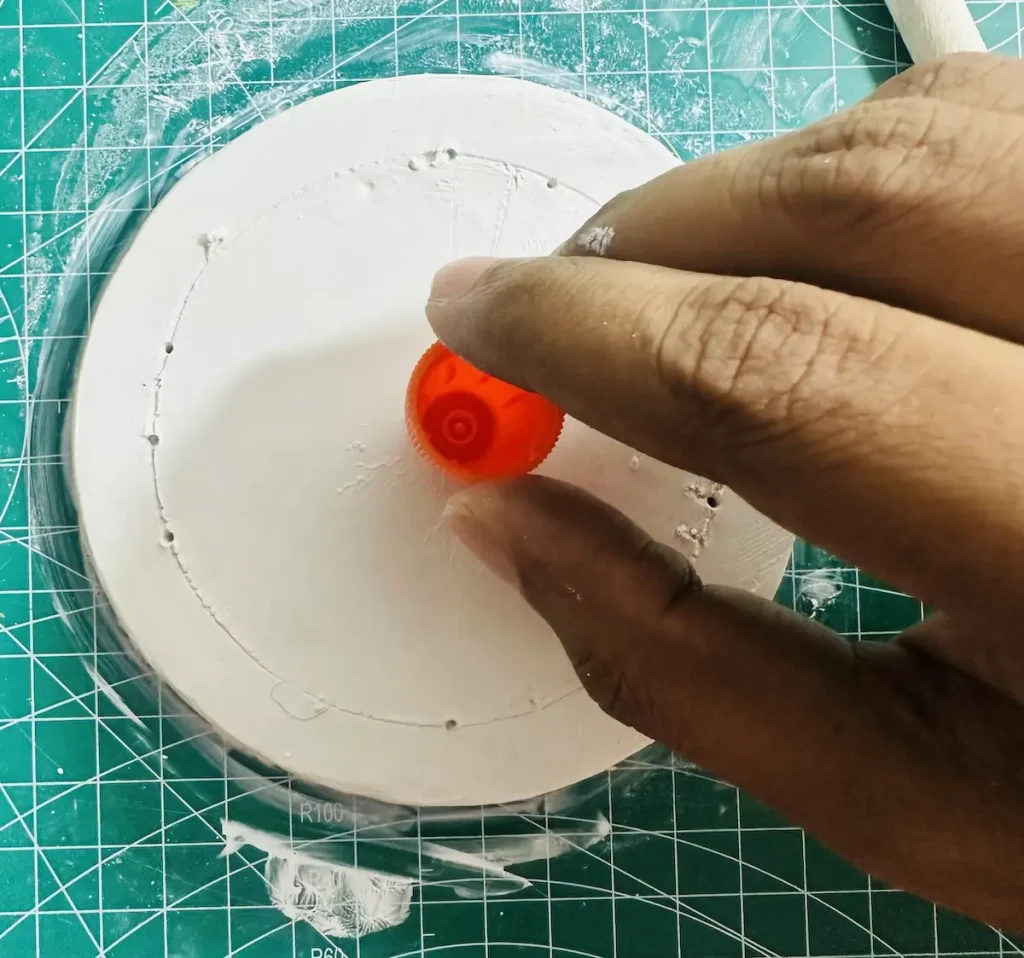 marking the middle of the tray base using a small cap