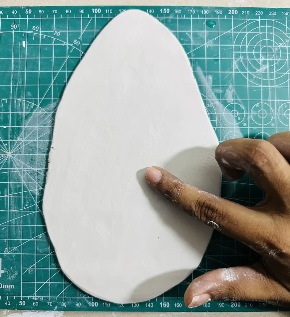 smoothing out the clay slab
