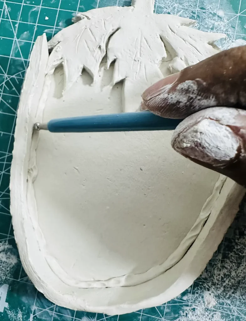 smoothing the thin clay coil