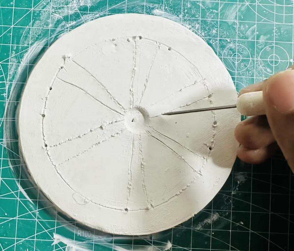 tracing the orange dividers before hollowing out the clay