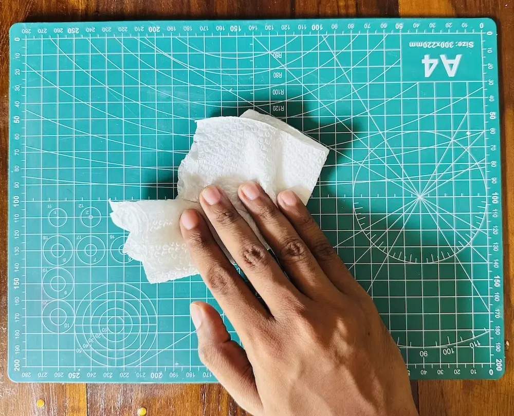 wiping dust on the PVC mat using a tissue papaer