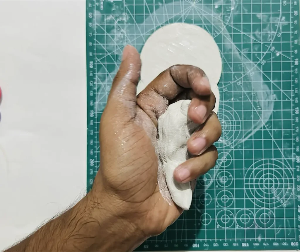 kneading a fresh clay piece to make the tray rim