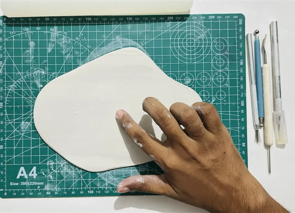 smoothing out the clay slab