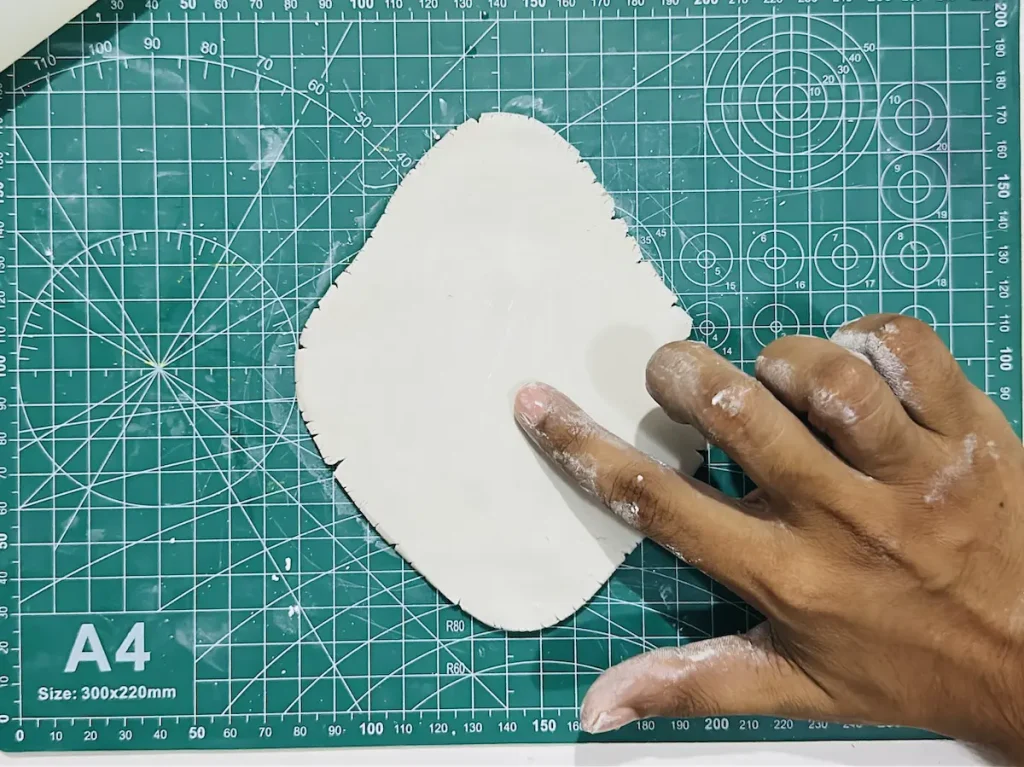 smoothing out the clay slab