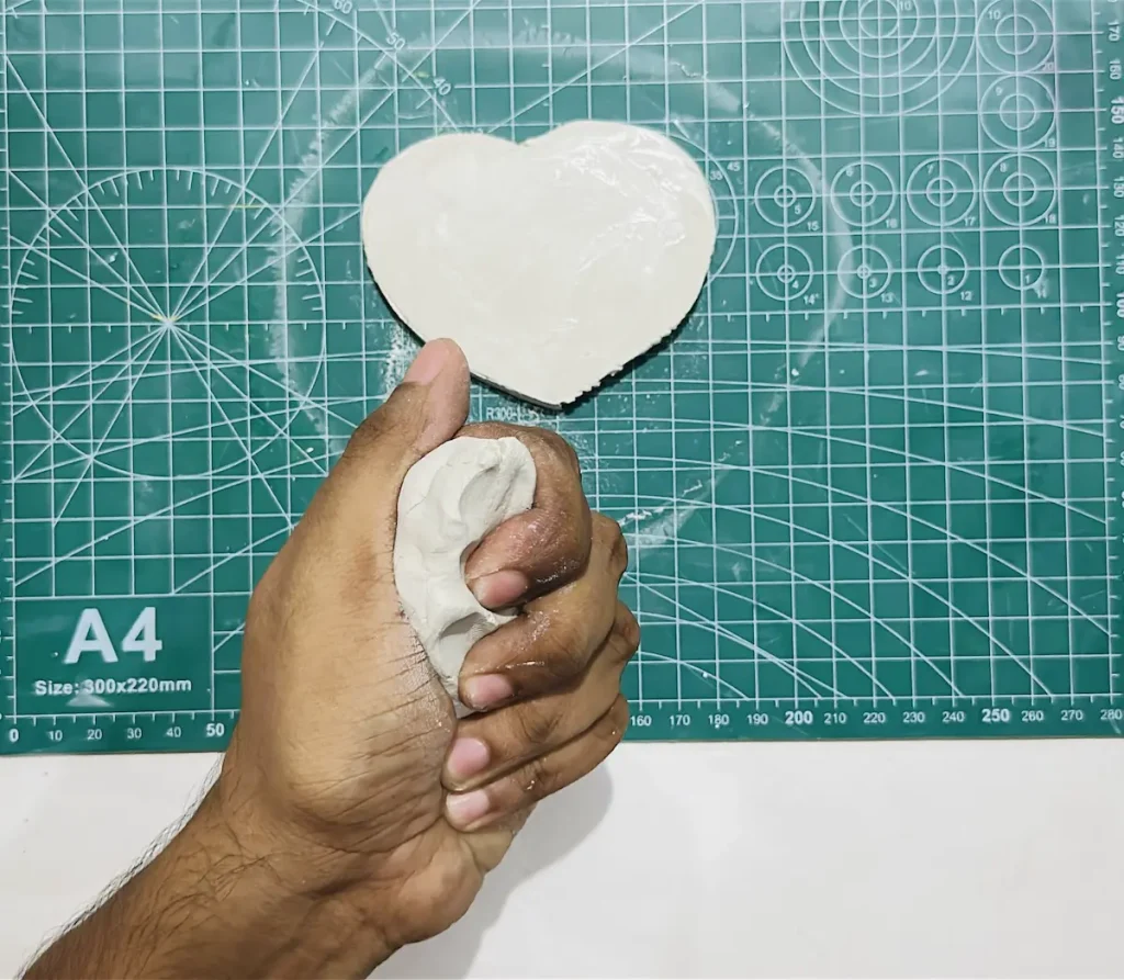 kneading fresh clay piece to make the tray rim