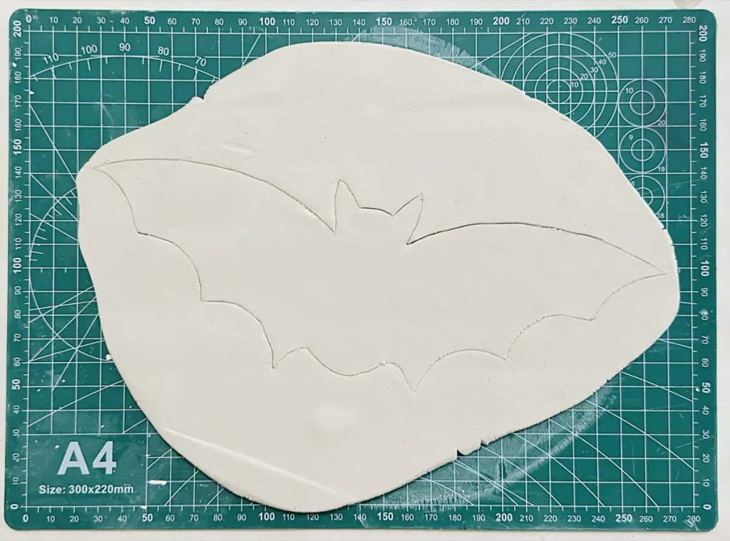 traced bat shape on the clay slab